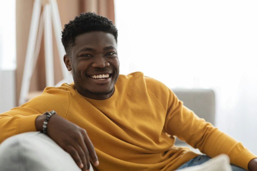 Portrait of happy black guy posing at home